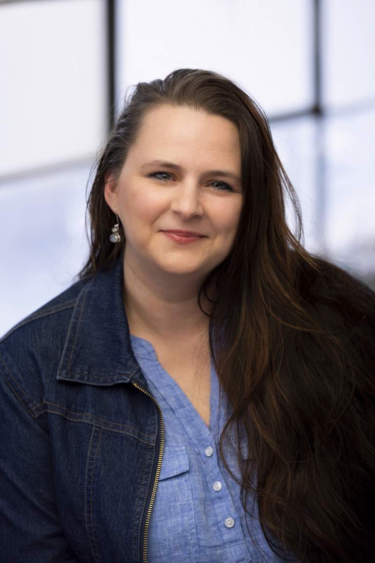 long haired female human services director in a windowed office